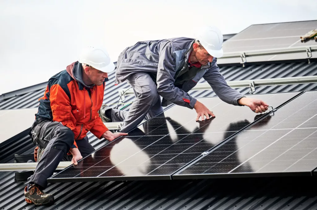 Construction Worker on Roof repairing Solar Panels